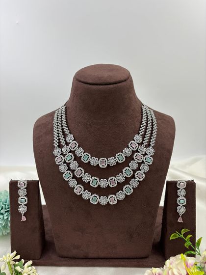 A three-row AD necklace set with square-cut stones. This classic and elegant design is available in all-white, mint green, ruby, blue, and a multi-color option.