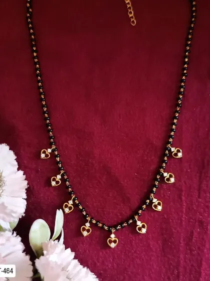 A charming mangalsutra with small heart-shaped charms hanging from the chain. It's a sweet and romantic design, perfect for daily wear.