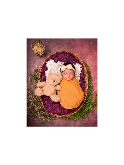 An overhead shot of a newborn and teddy bear in a basket. The composition is perfectly balanced, creating a timeless and heartwarming image.