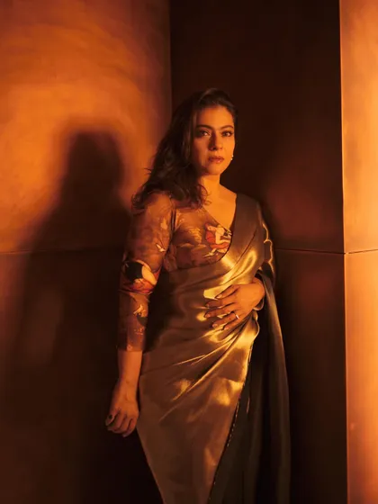 Kajol in a shimmering bronze and gold saree, a look that exudes warmth and glamour for an evening event.