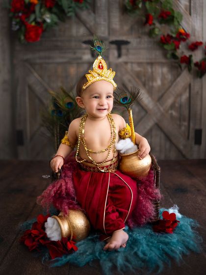 A happy little Krishna in a red dhoti, ready to cause some adorable mischief.