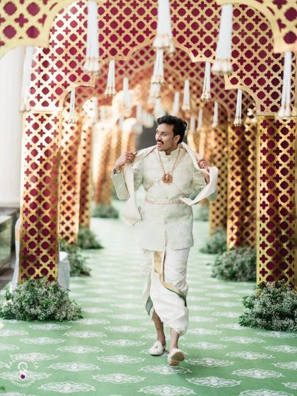 A candid shot of the groom during the Kashi Yatre, walking with a festive umbrella.