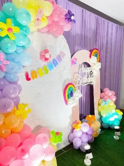 A close-up of our Rainbow theme balloon arch. This shot details the pastel-colored balloons and cute flower accents that add a special touch to the decoration.