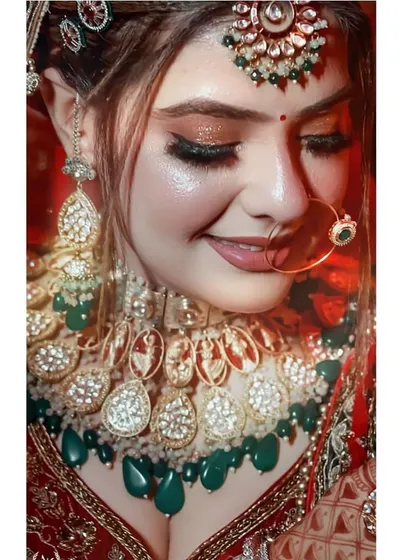 A close-up on the bride's happy face, highlighting the intricate details of her polki necklace and nath.