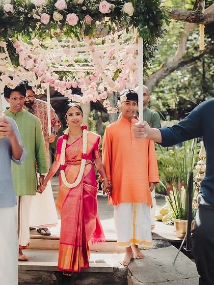 The bride's processional, walking down the steps of the Kalyani under a floral canopy held by her loved ones.
