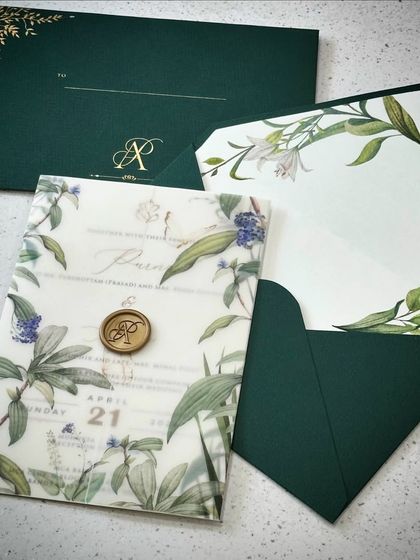 A vellum paper invitation with a botanical theme, designed for a bride. The dark green envelope and custom wax seal perfectly complement the beautiful floral illustrations.
