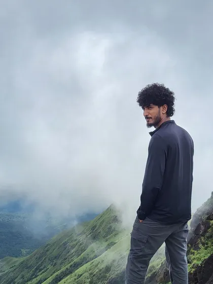 A trek lead looking out at the misty view from Kumara Parvatha.