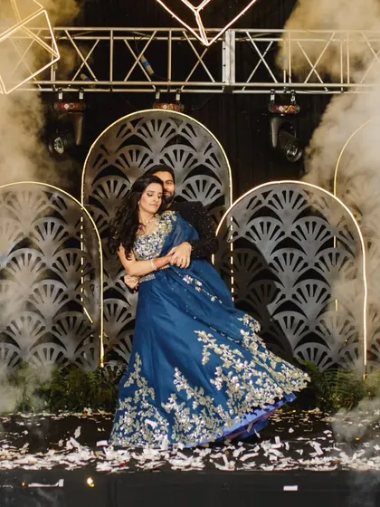 A stunning twirl in a beautiful blue lehenga against a dramatic stage setup. We help you create these breathtaking visuals for your wedding film.
