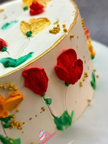 A close-up of the painted buttercream flowers, showing the texture and vibrant colours of this artistic cake decorating style.