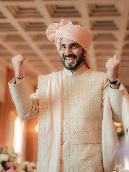 The groom's triumphant and happy expression during the wedding ceremony, a moment of pure celebration.
