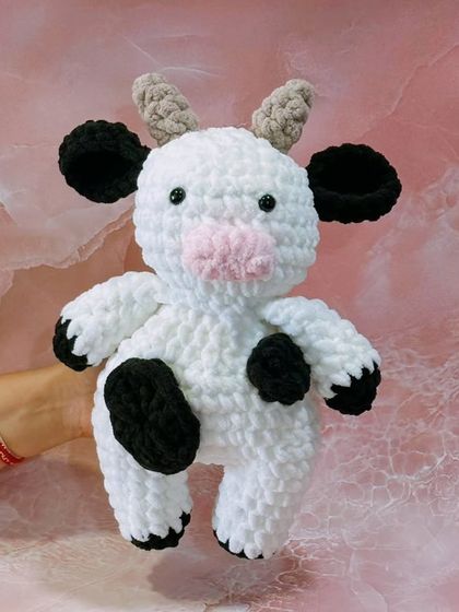 This adorable cow plushie is made with fluffy, cloud-like yarn, making it incredibly soft and huggable. The classic black and white spots and sweet face make it a delightful friend for all ages.