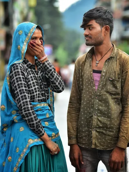 A candid moment between a young couple on the street. Her shy gesture and his gaze create a sweet, unposed story about their relationship.