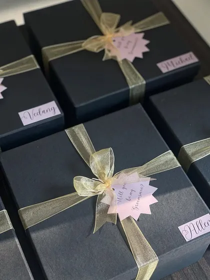 All packed and ready to go! These black groomsmen boxes are finished with a gold ribbon and a personalized name tag for that final elegant touch.