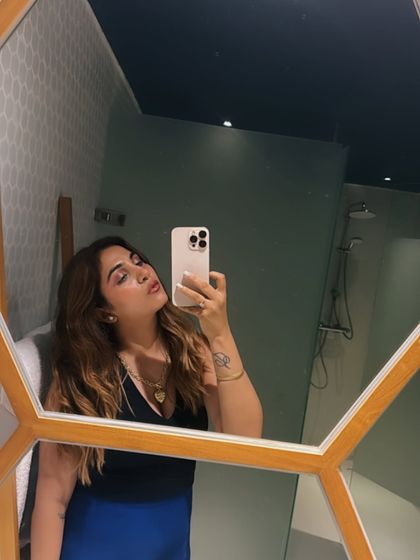 A final mirror selfie of the glam look. The black halter top and blue skirt combination is a classic, proving that sometimes, simplicity is the ultimate sophistication.