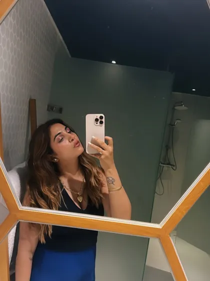 A final mirror selfie of the glam look. The black halter top and blue skirt combination is a classic, proving that sometimes, simplicity is the ultimate sophistication.