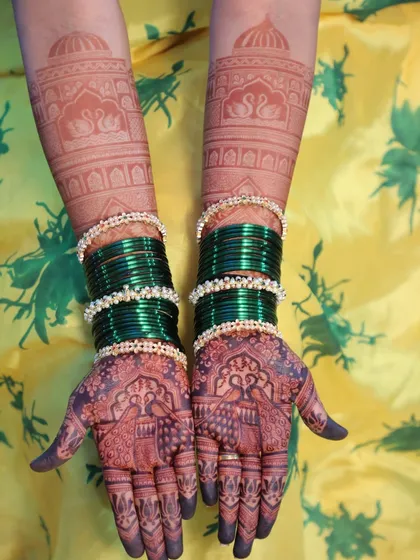 A beautiful shot of the bride's hands with her green bangles, showing the rich color of the mehendi stain.
