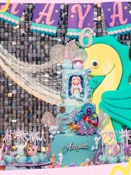 Diving into fun with an under-the-sea mermaid party. This incredible cake and backdrop, featuring a giant seahorse and shimmering details, set the stage for a fin-tastic celebration.
