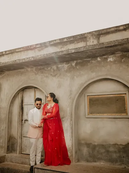 A classic pose against a textured, rustic backdrop. The contrast between their elegant outfits and the raw architecture makes for a compelling and artistic wedding portrait.