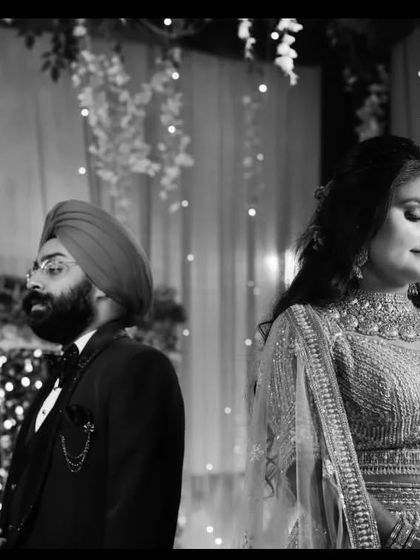 A timeless black and white photograph of the couple at their reception. The candid, unposed nature of the shot captures a genuine moment of quiet connection between them amidst the celebration.