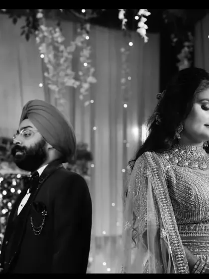 A timeless black and white photograph of the couple at their reception. The candid, unposed nature of the shot captures a genuine moment of quiet connection between them amidst the celebration.