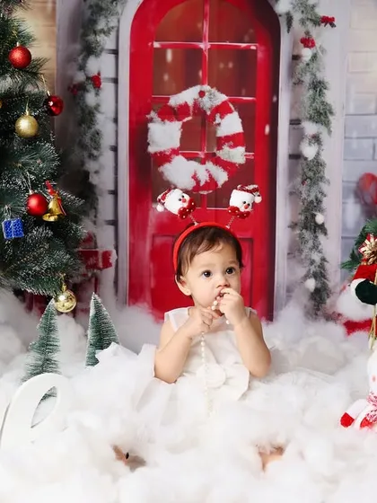 A candid shot of the birthday girl in her white dress, looking thoughtful amidst the festive Christmas decorations.