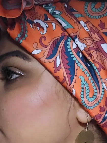 A side profile showing off my orange paisley turban wrap. It's a versatile accessory that can be styled in so many ways to elevate a look.