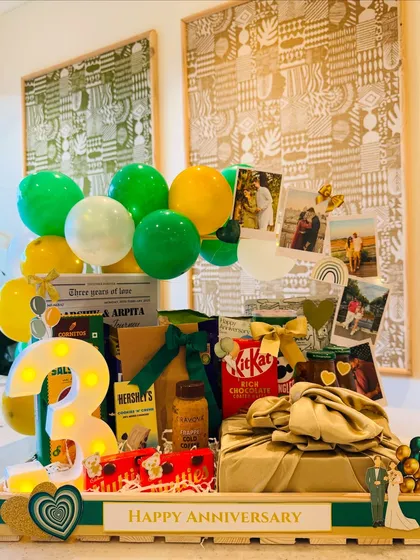A full view of the vibrant third-anniversary hamper, showing how the green and yellow balloons complement the emerald and gold theme.