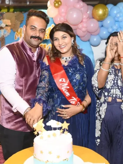 It's all about the candid moments. Here, the happy couple is surrounded by family during their baby shower cake-cutting ceremony, a moment of pure joy and anticipation.