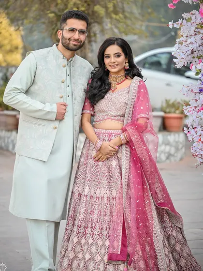 A classic portrait of the couple at their engagement in Solan, their pastel outfits complementing the floral decor perfectly.