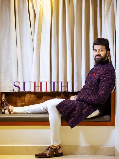 A relaxed and stylish portrait of the groom seated by a window.