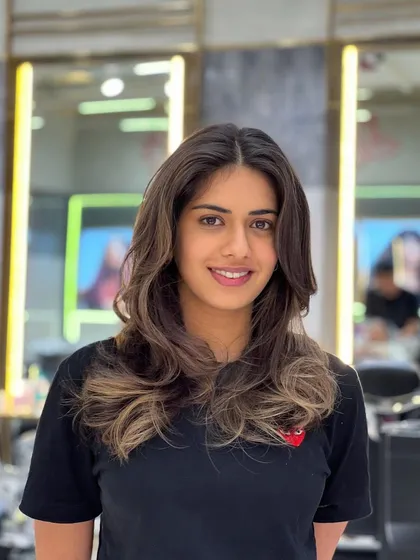 A smiling client showing off her new balayage. The soft layers and waves perfectly complement the color, creating a look that is both beautiful and full of life.