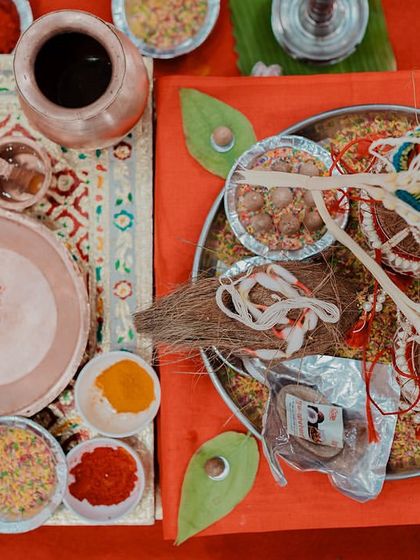 A top-down shot of the puja thali and other items for a Maharashtrian wedding ritual. These flat-lay shots add an artistic touch to your wedding album.
