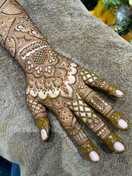 The palm side of Rabiya's Pakistani bridal henna, featuring a beautiful central mandala and detailed finger work.