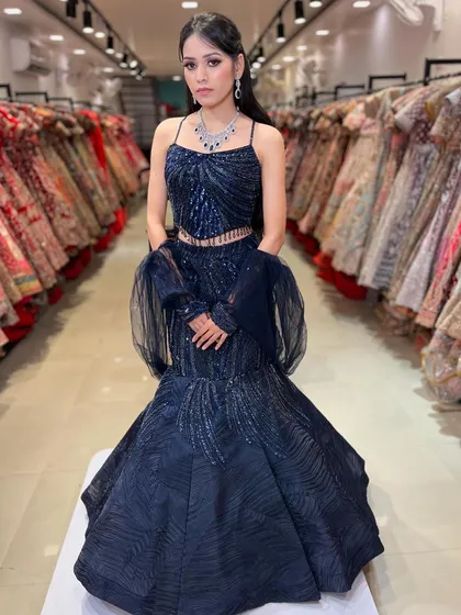 A full-length view of the stunning navy blue fish-cut lehenga. The dramatic flare at the bottom and the fitted bodice create a beautiful mermaid silhouette.