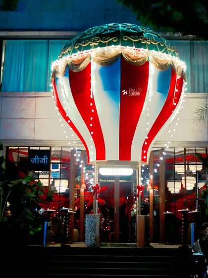 A giant hot air balloon structure installed at the entrance of Gigi restaurant, creating a spectacular and whimsical welcome for the holiday season.