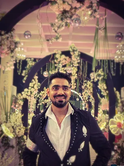 A close-up shot from a grand wedding event. The beautiful floral decor in the background complemented my embellished jacket perfectly.