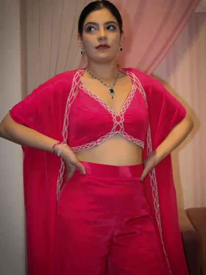 The full look of our pink co-ord set, which includes a bralette-style top, wide-leg pants, and a matching cape.