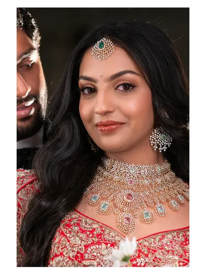 A beautiful close-up of Likitha's reception makeup. The soft glam look features a glossy nude lip and defined eyes, perfectly complementing her magnificent diamond jewelry set.