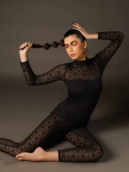 The full look from our student's editorial shoot, featuring a unique twisted ponytail and a dramatic pose. We teach our students to think about the entire creative concept.
