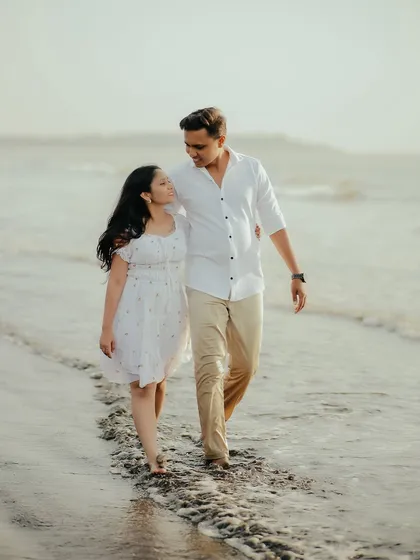 A simple walk on the beach, but with you, it's everything. This candid shot captures the natural interaction and loving gaze between the couple during their pre-wedding session.