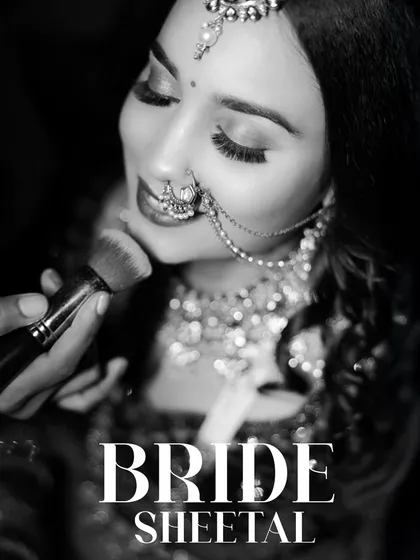 A timeless black and white shot of the bride getting a final touch-up. This behind-the-scenes moment captures the anticipation and excitement of getting ready for the big day.
