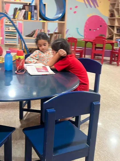 Two friends sharing a book is a common and heartwarming sight at our library. We encourage peer reading and learning, which helps build both literacy and social skills.
