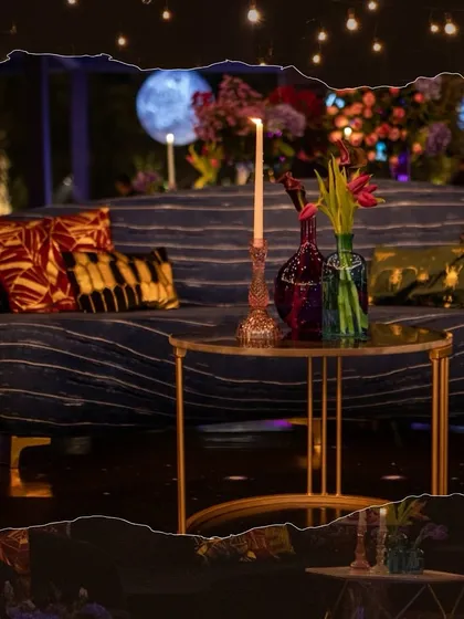 A stylish lounge moment with a pinstripe sofa, bold patterned cushions, and a sleek gold coffee table, all set against the backdrop of hanging planets and string lights.