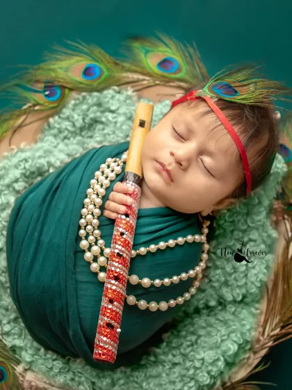 A newborn styled as little Krishna, complete with a peacock feather and flute. Even in their sleep, we can create these beautiful, culturally rich portraits.