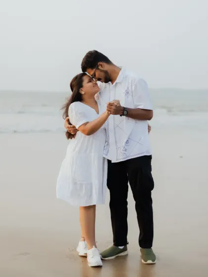 A full-length shot of the couple in a romantic pose on the beach, showcasing their connection and the beautiful seaside scenery.
