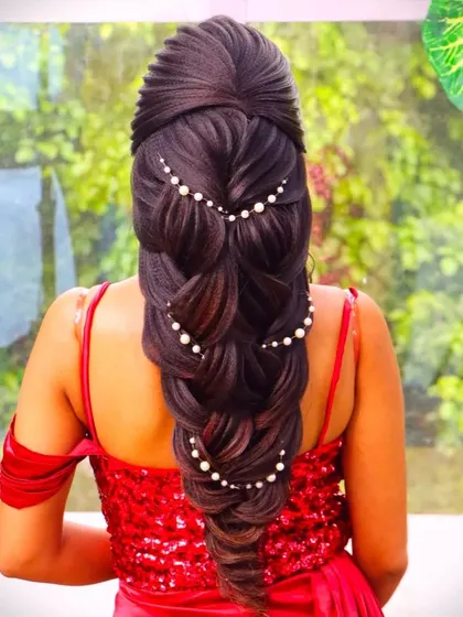 A mermaid braid hairstyle with beautiful leaf elements and pearl accessories. This is a highly detailed and artistic braid, perfect for a bride who wants a true work of art.