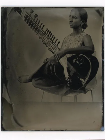 A portrait of a sitar player, captured on a glass plate. The wet plate process excels at rendering deep tones and a timeless quality, making it an ideal medium for capturing the essence of fellow artists and their craft.