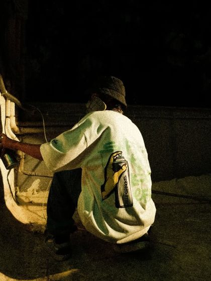 A moody shot of me painting at night, illuminated by a single spotlight. Some of the best work happens after the sun goes down.
