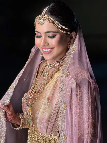 A joyful portrait of the bride, her smile lighting up her face. The makeup is designed to enhance her happiness and radiance.