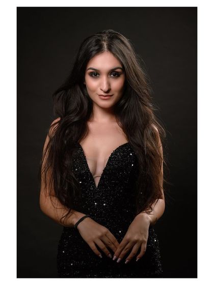 A glamorous studio portrait in a sequined black dress. The model's pose is elegant and sophisticated.